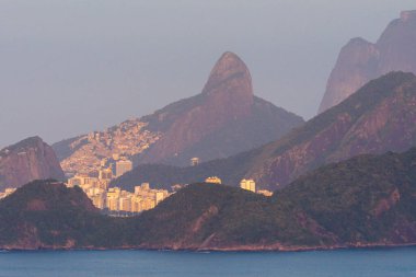 Rio de Janeiro, Brezilya 'da kırmızı gün doğumu ışığında dağların katmanlarına güzel bir manzara