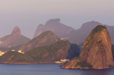 Rio de Janeiro, Brezilya 'da kırmızı gün doğumu ışığında dağların katmanlarına güzel bir manzara