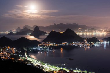Rio de Janeiro, Brezilya 'da gece okyanus ve karanlık dağ siluetleri için güzel bir manzara