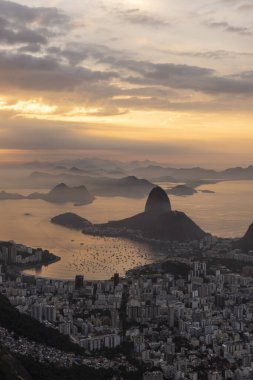 Rio de Janeiro, Brezilya 'da renkli gündoğumu bulutlarıyla şehre, dağlara ve okyanusa güzel bir manzara