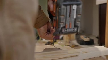 Kablosuz tornavida tahtadan bir kirişe vida takıyor.,