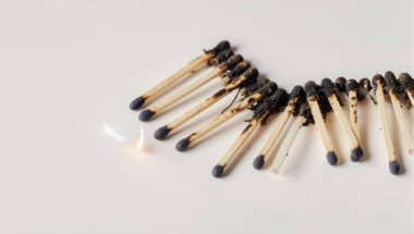 Beyaz bir yüzeye yakın plan yanmış kibrit çöpleri, tükenmeyi, tükenmeyi ve yıkıcı bir olayın sonucunu sembolize ediyor..