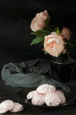 Siyah arka planda meyveli şekerlemelerle dolu bir hayat. Yuvarlak marshmallow rosette.