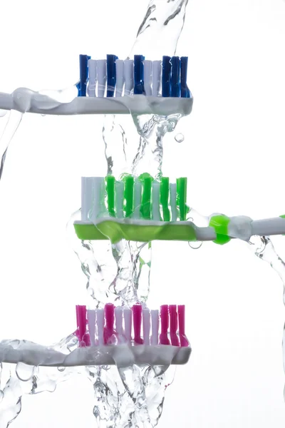 Toothbrushes under splashing water — Stock Photo, Image