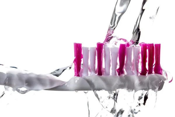 Зубная щетка с каплями под брызгами воды . — стоковое фото