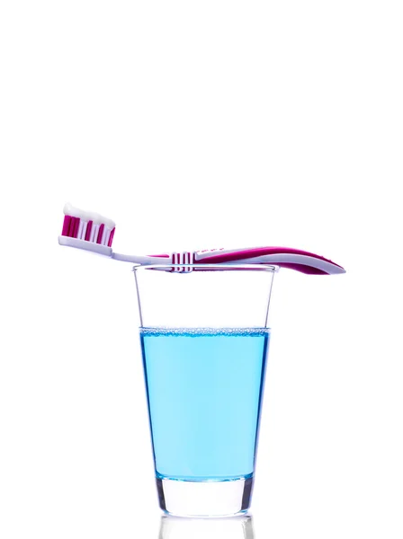 Cepillo de dientes en vidrio con enjuague bucal aislado en blanco — Foto de Stock
