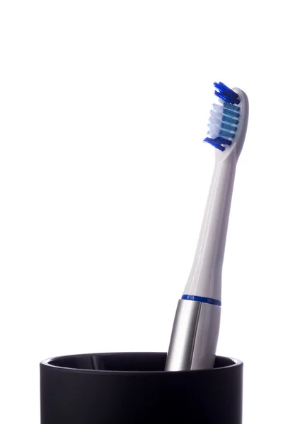 Toothbrush in black cup isolated on white — Stock Photo, Image