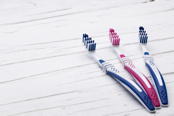 Toothbrushes on white wooden background — Stock Photo, Image