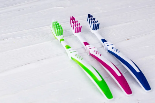 Toothbrushes on white wooden background — Stock Photo, Image