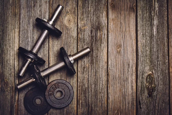 Fitness workout background. Dumbbells on wooden floor — Stock Photo, Image