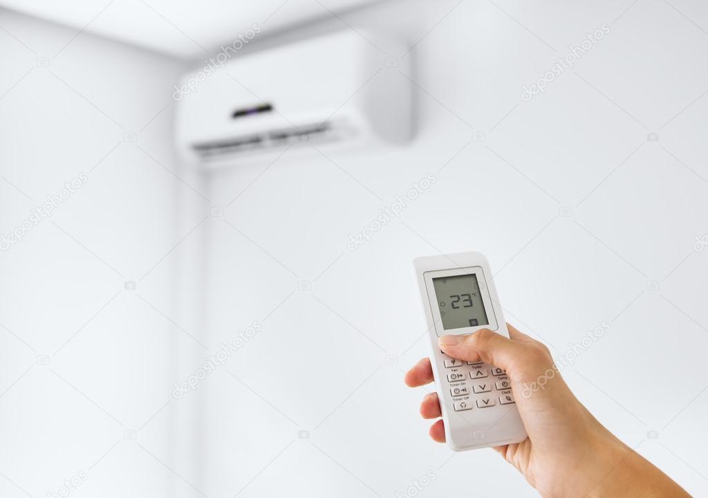 Remote control for air conditioner on a white wall.