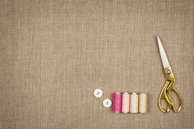 Doğal bir keten üzerinde düz yatan dikiş nesneleri grubu