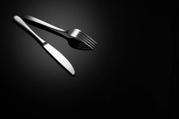 Černá potravin pozadí s nožem a vidličkou — Stock fotografie
