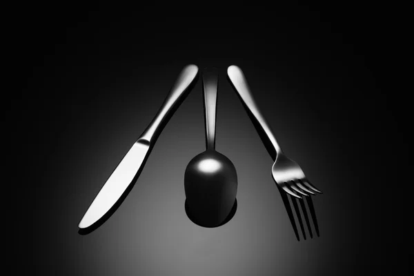 Black food background with knife, fork and spoon — Stock Photo, Image