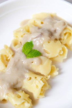 Beyaz tabakta kremalı Durian hindistan cevizi soslu Roti Jala.