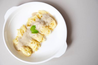 Beyaz tabakta kremalı Durian hindistan cevizi soslu Roti Jala.