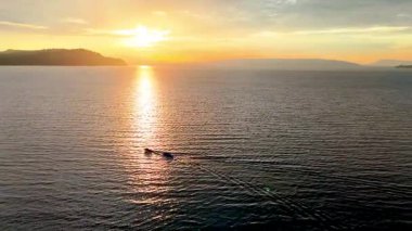 Toba Gölü 'nde yelken açan muz teknesinin sinematik hava görüntüsü.