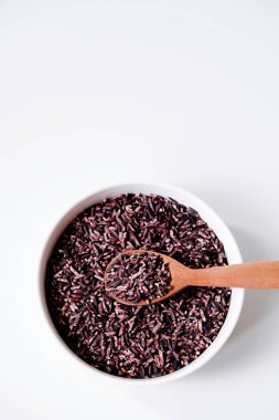 Beyaz arka planda izole edilmiş bir kase siyah pirinç taneciği.