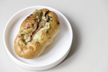 Beyaz tabakta füme sığır eti, pesto ve peynirli zanaatkar tuzlu ekmek.