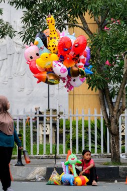 Pekanbaru, Endonezya - 28 Eylül 2025: Pazar Arabasız Gününde balon satıcısı