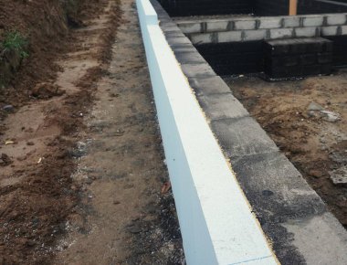 Görünür yalıtımlı ev yapımı. Duvar köpüğü ve yalıtımlı malzemeler, alçı için hazırlanıyor. Enerji verimliliği için modern termal yalıtım ile inşaat devam ediyor.