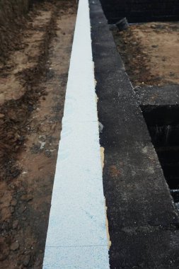 Görünür yalıtımlı ev yapımı. Duvar köpüğü ve yalıtımlı malzemeler, alçı için hazırlanıyor. Enerji verimliliği için modern termal yalıtım ile inşaat devam ediyor.