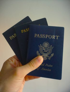 Elde tutulan bir Amerikan pasaportu yasal ikamet ve Amerikan vatandaşlığını gösteriyor. Yakın plan, belgenin kapağını ve özgünlüğünü vurgular.