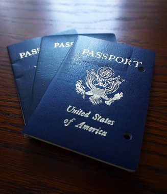 Elde tutulan bir Amerikan pasaportu yasal ikamet ve Amerikan vatandaşlığını gösteriyor. Yakın plan, belgenin kapağını ve özgünlüğünü vurgular.