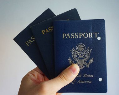 Elde tutulan bir Amerikan pasaportu yasal ikamet ve Amerikan vatandaşlığını gösteriyor. Yakın plan, belgenin kapağını ve özgünlüğünü vurgular.