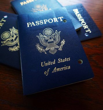 Elde tutulan bir Amerikan pasaportu yasal ikamet ve Amerikan vatandaşlığını gösteriyor. Yakın plan, belgenin kapağını ve özgünlüğünü vurgular.