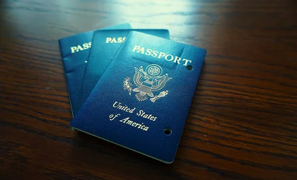 Elde tutulan bir Amerikan pasaportu yasal ikamet ve Amerikan vatandaşlığını gösteriyor. Yakın plan, belgenin kapağını ve özgünlüğünü vurgular.