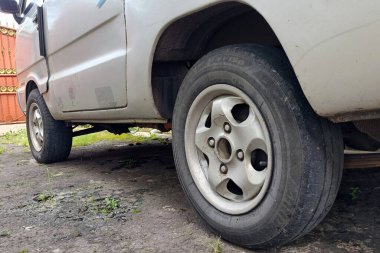 Yaşlı Suzuki 'nin yan görünüşü araba lastiği taşıyor.