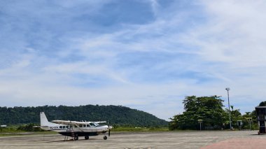 Tropikal bir yerdeki havaalanı pistinde küçük, sabit bir uçak parkı. metin için boşluk kopyala