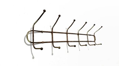 Beyaz arka planda izole edilmiş eski bir pirinç metal duvar monte edilmiş kanca askısı.