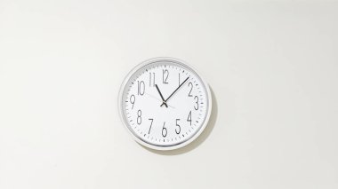 Yuvarlak kadranda açıkça rakamlar, saat, dakika ve saniyelik gösteriliyor, ayrıca belirgin bir işaret var, hepsi de sade bir arkaplanda izole edilmiş..