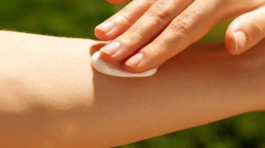 Açık havada cilt koruması için Kol üzerine güneş kremi sürülüyor