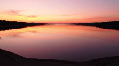 Alacakaranlık 'taki Sakin Göl' ün Göz kamaştırıcı Pembe Gün Batımı Yansıması