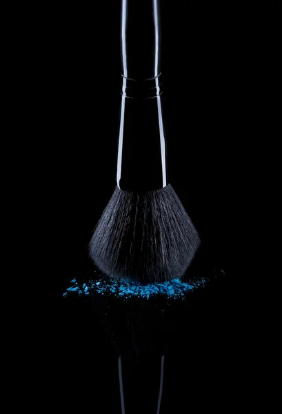 Brosse avec poudre bleue isolée sur noir — Photo