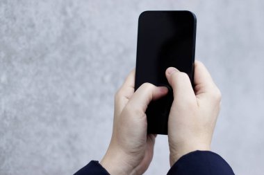 Tarafsız bir arkaplanda akıllı telefonu tutan eller. Yüksek kalite fotoğraf