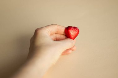 El ele tutuşan kırmızı kalp şeklinde çikolata şekeri. Yüksek kalite fotoğraf