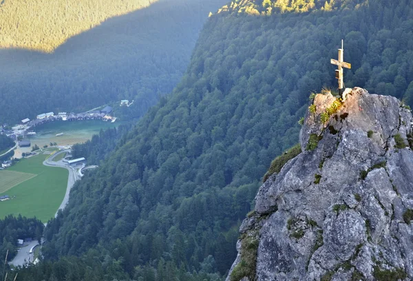 Rock with illuminated cross above a valley — Stock Photo, Image