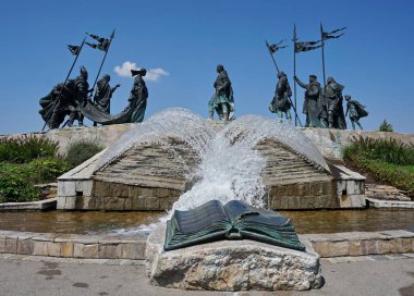 Birbirine püsküren iki sıra hortumla çeşme. Çeşmenin önünde, taşın üzerindeki metalden yapılmış bir kitap heykeli bulunuyor. Çeşmenin arkasında tarihsel savaşçılardan oluşan tarihi bir anıt bulunuyor. Tulln, Avusturya