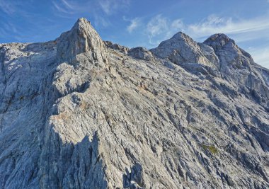 Dağlar - Avusturya 'da Alpler. Berchtesgaden Alpleri 'ndeki Konigsjodler yolu üzerinden. Dağ sırtı, bazı zirveleri olan sarp kayalardan oluşmuştur. Arka planda bulutlar olan mavi gökyüzü.