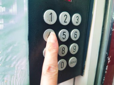 Ors vezer tere Budapeşte 'deki bir apartman dairesinin giriş panelindeki metal düğmeye basarak bir parmak kapat. Bir yerleşim bölgesinde güvenlik, erişim ve kentsel yaşam kavramı.