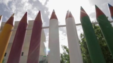 Renkli ahbaplık. Alışılmadık çitler, renkli kalemler şeklinde çitler. Güneşli bir gün.