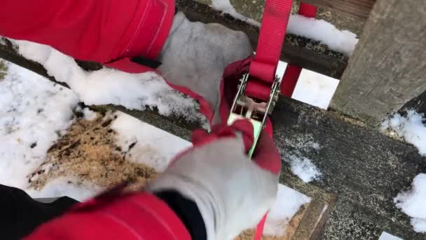 Bevestiging van een houten stam met een ratelriem — Stockvideo