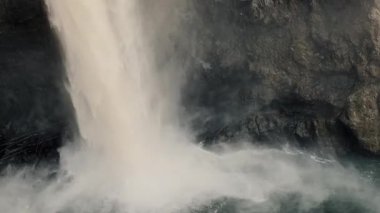 Nehre dökülen güçlü bir şelale ile yukarı doğru doğal manzara, vahşi doğanın güzelliğini ve gücünü vurguluyor..