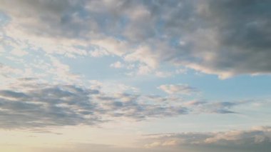 Yumuşak beyaz bulutlar uçsuz bucaksız mavi gökyüzünde yavaşça süzülür. Bu sakin zaman atlamasında, doğanın sakin ritmini ve güzelliğini yakalar..