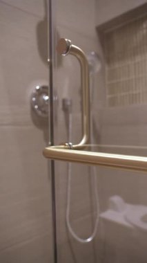 Modern metal duş kapısının kapağını banyonun içinde kapat. Temiz tasarım, cam yüzey, tarafsız fayanslar ve minimal tarz. Hijyen, konfor ve ev dekorasyonu kavramı.