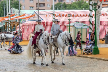 Seville, İspanya - 5 Mayıs 2019: Ata binen ve Seville 'deki Nisan Fuarı' nı (Feria de Sevilla) kutlayan güzel kadınlar. Seville Nisan Fuarı 5 Mayıs 2019, Sevilla, İspanya